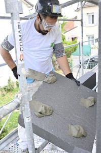 Chantier d'isolation thermique par l'extérieur avec un ouvrier qui pose le système Armaterm au mur - ZOLPAN