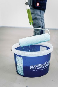 Homme entrain d'utiliser un rouleau dans un produit Uzin pour le ragreage d'un sol interieur Zolpan